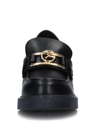 Scarpa di pelle nera con texture liscia, caratterizzata da una punta arrotondata e un accento circolare in oro su una fascia nera che attraversa il collo del piede.