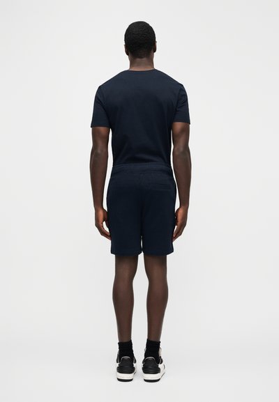 Μπλε βαμβακερό μπλουζάκι ναυτικού τύπου συνδυασμένο με αντίστοιχα σορτς σε μπλε, με άνετη εφαρμογή και ελαστική μέση, από πίσω όψη.