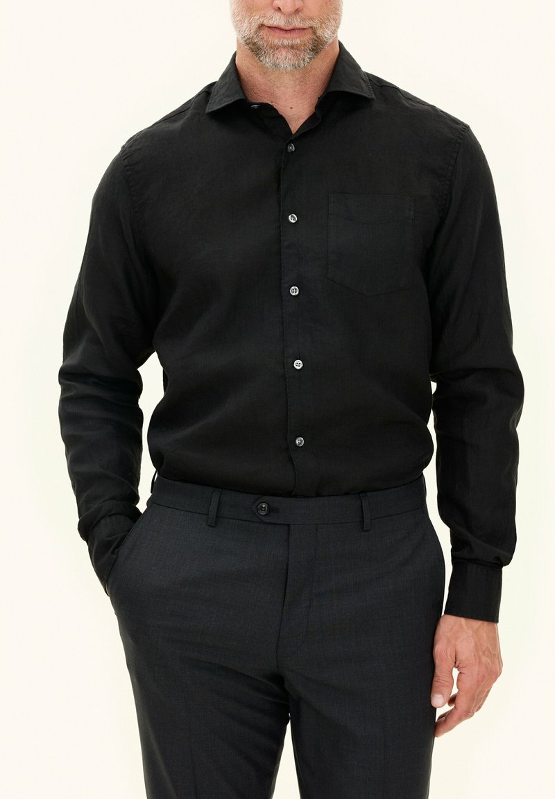 Zwarte langearmige shirt in een linnenmix met een borstzak, button-down kraag en een knoopsluiting aan de voorkant, gecombineerd met donkere broeken.