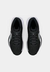 Zapatillas deportivas negras con una parte superior texturizada, cordones grises y detalles en blanco. Suela lisa con forma redondeada y interior acolchado.