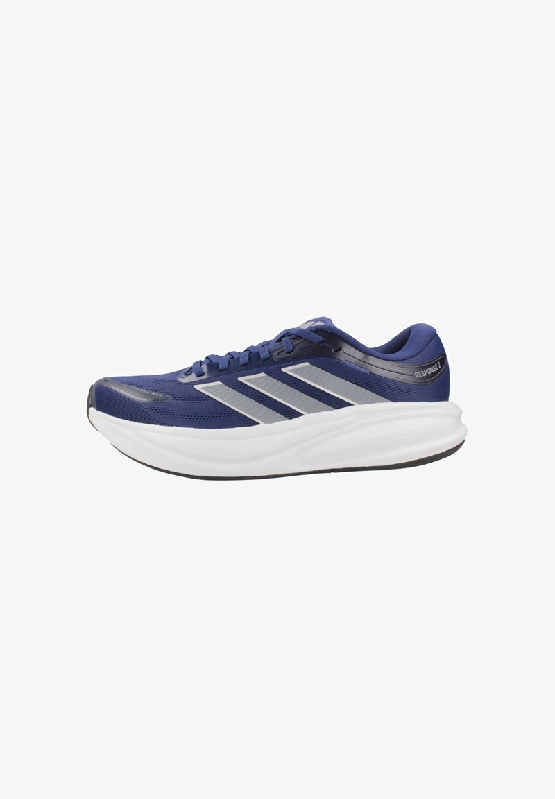 Chaussure de course bleu marine avec des rayures argentées, une semelle épaisse blanche rembourrée, et un design à lacets vue de profil.