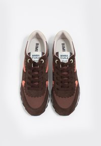 Brązowe trampki z różowymi akcentami, cholewka ze skóry zamszowej i syntetycznej, okrągły nosek, sznurowane, z czarną gumową podeszwą. Widoczne logo "BIMBA Y LOLA".