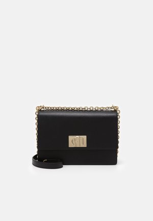 Zwarte leren crossbodytas met gouden kettingriem en rechthoekige gouden sluiting op de voorflap, afgebeeld tegen een effen witte achtergrond.