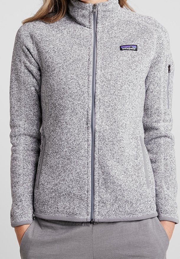 Graue Fleecejacke mit hohem Kragen und durchgehendem Reißverschluss. Verfügt über Seitentaschen und ein kleines Logo auf der Brust. Glatte Textur, taillierte Passform.