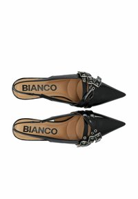 Tacchi a slingback in vernice nera con punta affilata, cinturini incrociati e dettagli con fibbie metalliche. Soletta beige morbida con marchio.