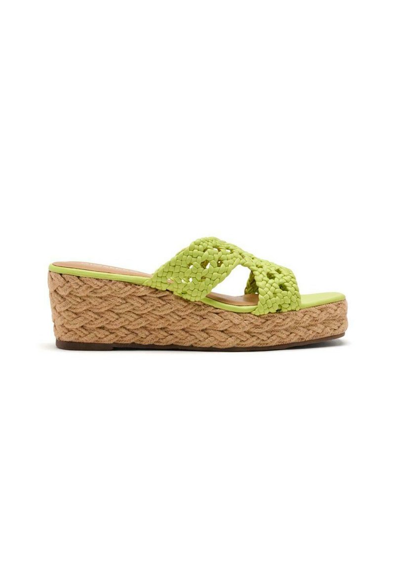 Sandalia de cuña con un brillante upper tejido en verde y una plataforma de yute tejido. La suela es marrón con un acabado texturizado para mayor agarre.