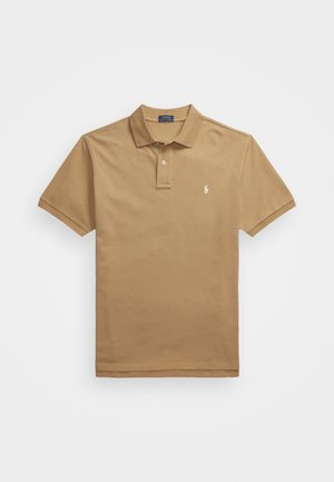 Tan polo shirt made of cotton, featuring a classic collar, short sleeves, and a small embroidered logo on the left chest.