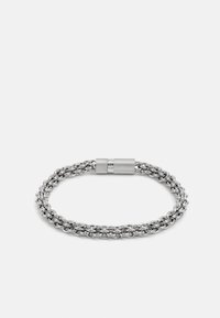 Silver metal bracelet made of interwoven links with a textured clasp. Features a smooth finish and a circular shape.