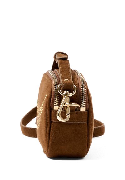 Bruine suède crossbodytas met dubbele gouden ritsen en een gouden metalen sluiting aan de zijkant, gezien vanuit een zijaanzicht.