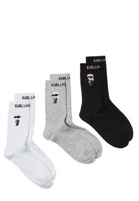 Tři páry ponožek Karl Lagerfeld: bílé, šedé a černé. Každý pár obsahuje název značky a karikaturu muže ve slunečních brýlích.