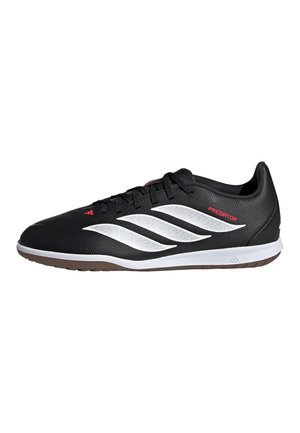 Schwarzer Adidas Predator Fußballschuh mit weißen Streifen, rotem Logo-Schriftzug, schwarzen Schnürsenkeln und weißer Sohle mit braunem Boden.
