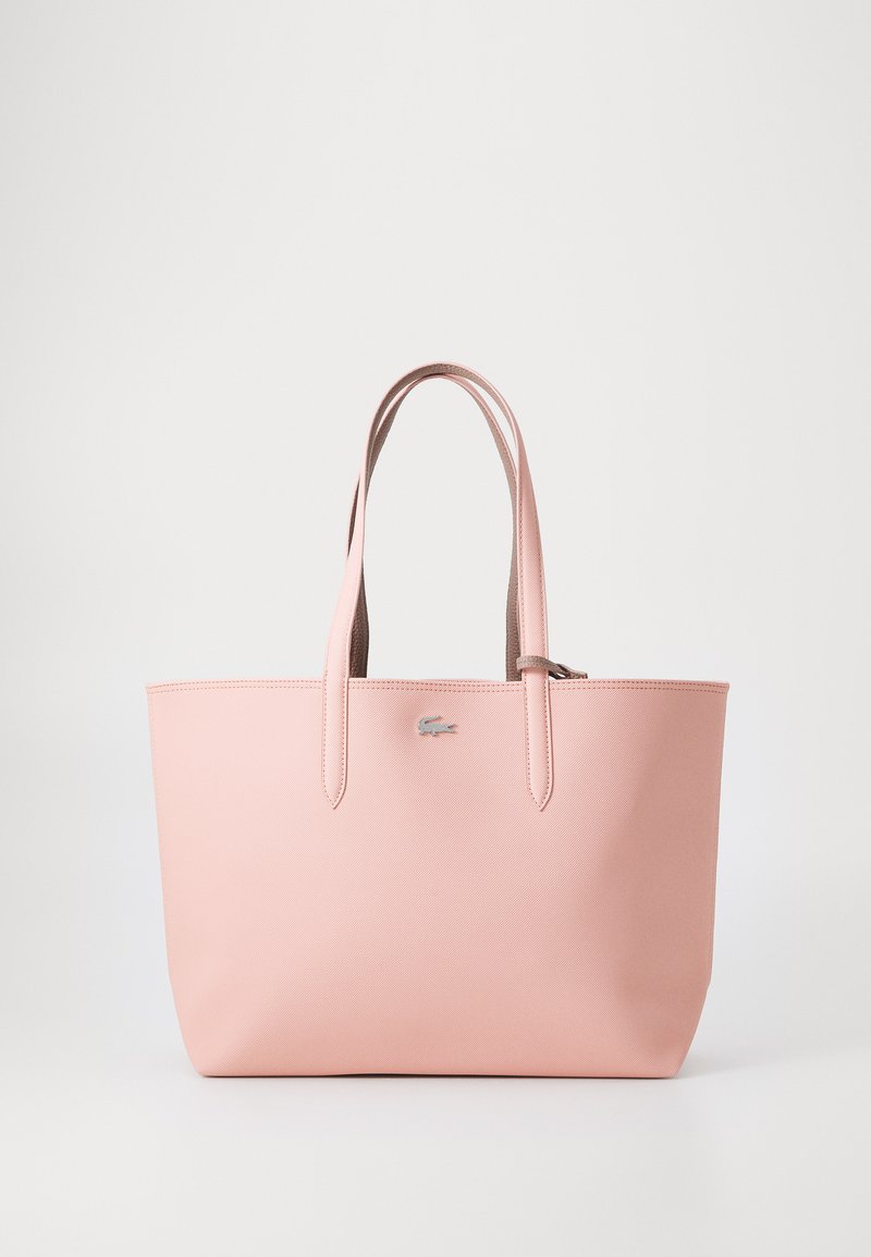 Bolsa tote sintética rosa com duas alças, textura suave e detalhe de logotipo discreto. Apresenta uma forma estruturada e fecho com zíper.