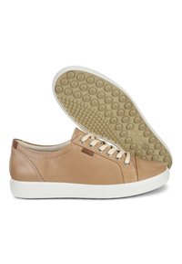 Baskets en cuir marron clair avec une finition lisse, semelle en caoutchouc blanche et points de traction ronds au bas. Comprend des lacets beige et un détail de logo.