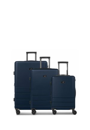 Three navy blue hard-shell suitcases in varying sizes, featuring textured surfaces, retractable handles, and 360-degree spinner wheels.