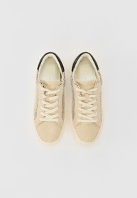 Sneakers beige con lacci, realizzati in tessuto a maglia testurizzato, accento sul tallone nero e suole in gomma. Lacci piatti e interni imbottiti per il massimo comfort.