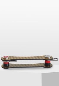 Kolfiber multifunktionsverktyg med en slank, platt design. Har röda accenter och hårdvara i rostfritt stål. Mönstrad yta med texturerat grepp.