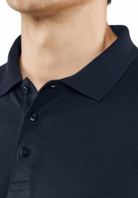 Marineblaue Polohemd aus strukturiertem Stoff, mit zwei Knöpfen und einem klassischen Kragen, das eine Nahaufnahme des Ausschnitts und des Schulterbereichs zeigt.