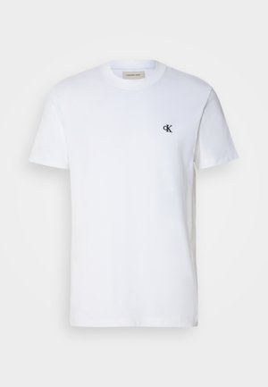 Witte katoenen t-shirt met korte mouwen en een ronde hals. Heeft een klein zwart "ck" logo op de linker borst. Klassieke pasvorm. Gladde textuur.