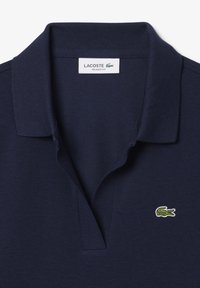 Mörkblå polo T-shirt med ribbad krage, prydd med en grön broderad krokodil-logotyp på vänster bröst och en avslappnad passform.
