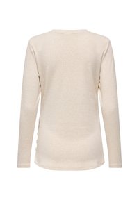 Μπεζ πουκάμισο μακρυμάνικο με στρογγυλή λαιμόκοψη, απλή πλάτη και διακοσμητικά κουμπιά κατά μήκος μιας πλευρικής ραφής.