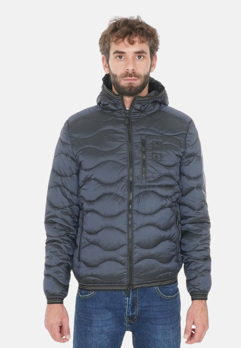 Giacca imbottita grigio scuro con cappuccio, caratterizzata da una chiusura frontale con zip, polsini a coste e motivi ondulati in rilievo sul tessuto.