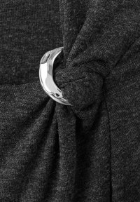 Țesătură gri închis, răsucită și legată în jurul unui inel metalic argintiu strălucitor; textura pare moale și ușor texturată.