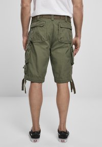 Olíva zöld cargo sort több oldalzsebbel, övlyukakkal ellátott övvel és megkötős alsó részletekkel. Tartós pamutanyagból készült.