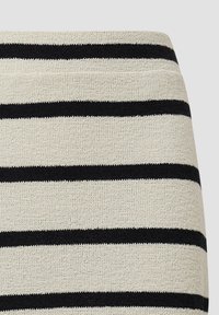 Strickrock mit abwechselnd schwarzen und cremefarbenen horizontalen Streifen. Texturierter Stoff mit figurnahen Schnitt, geeignet für verschiedene Anlässe.