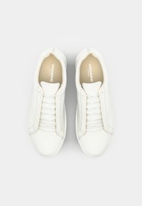 Baskets en cuir blanc avec une finition lisse, dotées de lacets plats, d'un bout rond et d'un design minimaliste. Nom de la marque visible à l'intérieur.