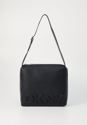 Schwarze Schultertasche aus strukturiertem Leder mit verstellbarem Riemen und großem, geprägtem DKNY-Logo auf der Vorderseite.