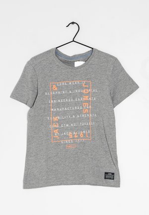 Grijs T-shirt met korte mouwen en oranje-witte tekst "Jack & Jones 1975", hangend aan een zwarte plastic hanger tegen een witte achtergrond.