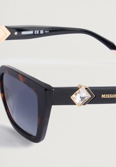 Svart og skjoldpaddemønstrede overdimensjonerte solbriller med gradientlinser, med gullakenter og klare rhinesteiner på armen.