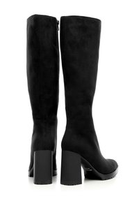 Botas de ante negras hasta la rodilla con tacón cuadrado, que cuentan con un cierre lateral y un acabado suave, mostrando un diseño moderno y elegante.