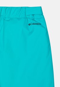 Tirkizne Columbia šortse s elastičnim pojasom, glatkom površinom i malim crnim logom sa strane.
