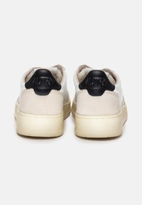 Sneakers bianchi in pelle con dettagli in suede beige; cappuccio posteriore nero con logo "AUTRY"; forma arrotondata; suola intermedia testurizzata.