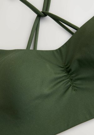 Top de bikini verde hecho de tela elástica. Presenta un centro fruncido y múltiples tiras delgadas entrelazadas en la parte posterior. Textura suave.
