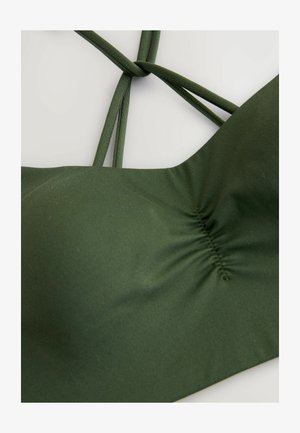 Top de bikini verde hecho de tela elástica. Presenta un centro fruncido y múltiples tiras delgadas entrelazadas en la parte posterior. Textura suave.