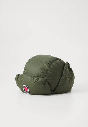 Chapeau rembourré vert olive avec un bord replié, présentant une patch de marque circulaire avec un logo rouge sur le devant, mettant en avant un design texturé et isolé.