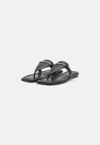 Sandali neri in pelle con un design minimalista, suola piatta e catena dorata decorativa sulle cinture superiori.