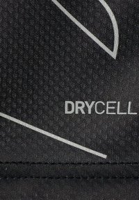 Svart tyg med ett strukturerat mönster, som har en vit böjd linje och ordet "DRYCELL" i fet stil.