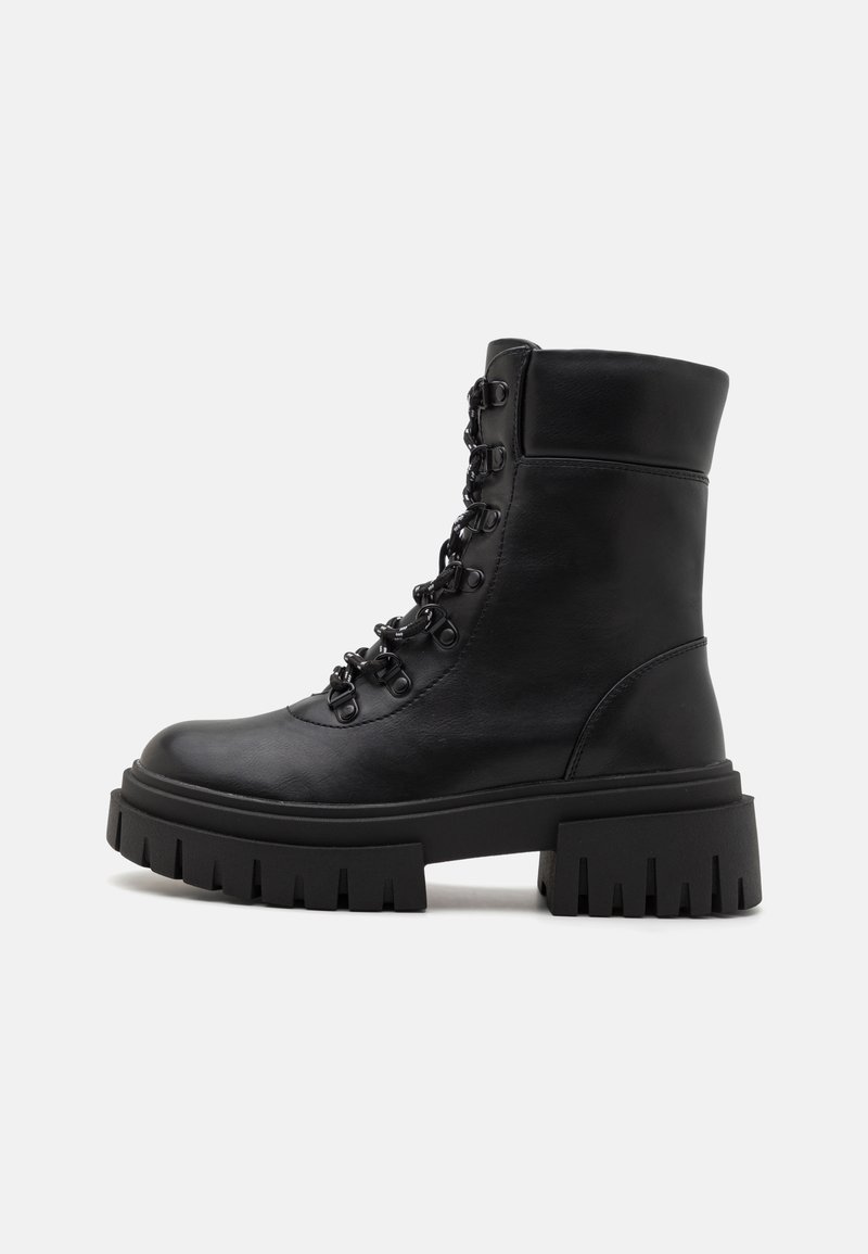 Musta nahka nilkkaboots, joissa on paksu, uritettu pohja. Huomaamattomat metalliset silmukat ja nauhat edessä sekä pehmustettu kaulus.