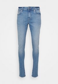 Jeans de mezclilla azul claro con un corte ajustado. Presenta cinco bolsillos, cremallera, cierre de botón metálico y un ligero desgaste en la tela.