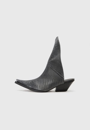 Sorte hæle mules med spids tå og et struktureret slangeskinds mønster. Har en lav, trekantet hæl og et glat, buet overdel design.