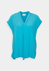 Blusa turchese in tessuto morbido, con scollatura a V, maniche corte e silhouette rilassata con un dettaglio drappeggiato davanti.