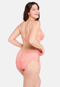 Reggiseno in pizzo corallo con culotte a vita alta abbinate. Dettagli in pizzo sul retro, motivo floreale e spalline regolabili. Tessuto con finitura liscia.