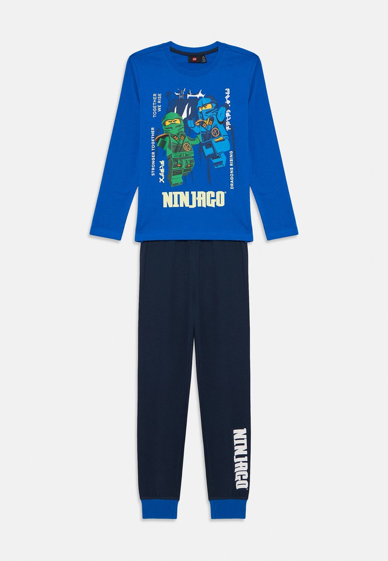 Modrá dlhá košeľa s grafickým motívom Ninjago, kombinovaná s námorníckymi nohavicami s modrým manžetovým lemom a bielym textom "Ninjago" pozdĺž strany.