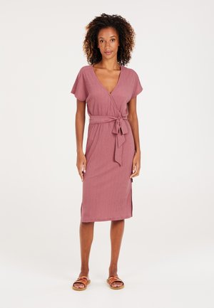 Sukienka typu wrap w kolorze mauve, z krótkimi rękawami, z paskiem w talii, wykonana z miękkiego materiału o fakturze, do kolan, z bocznymi rozcięciami, w zestawie z brązowymi sandałami na paski.
