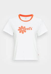 Bílý bavlněný tričko s kulatým oranžovým límcem, s velkým oranžovým květinovým grafickým vzorem a textem "Levi's" vytištěným na přední straně.