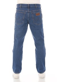 Jeans in denim blu con un design a gamba dritta, caratterizzati da una toppa in pelle in vita e cuciture zigzag sulle tasche posteriori.