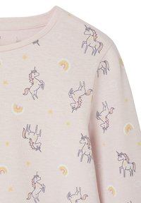 Light pink fabric with printed unicorns, rainbows, stars, and clouds, featuring a round neckline and long sleeves.